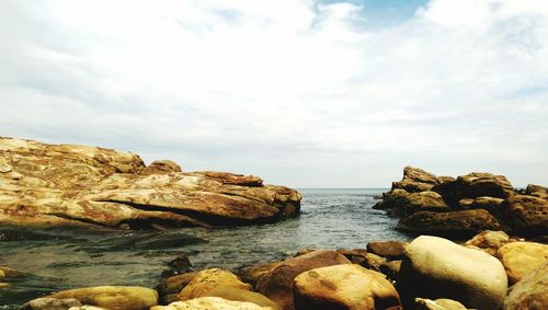 Rocks in sea against sky