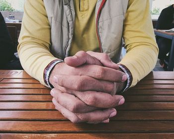 Midsection of man sitting on table