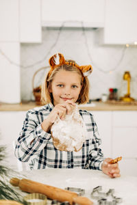 A cute girl in tiger ears is baking cookies for christmas or new year. symbol of the year,