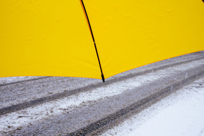 View under umbrella in front of snowy road