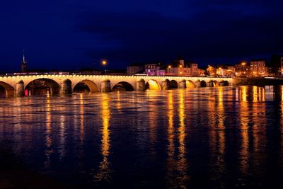 Illuminated arch bridge over saone river in city against sky