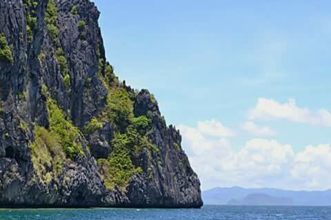 water, sea, mountain, waterfront, scenics, tranquil scene, tranquility, beauty in nature, rock formation, sky, rock - object, nature, cliff, idyllic, rock, blue, mountain range, day, outdoors, non-urban scene