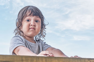 Portrait of cute boy looking away against sky