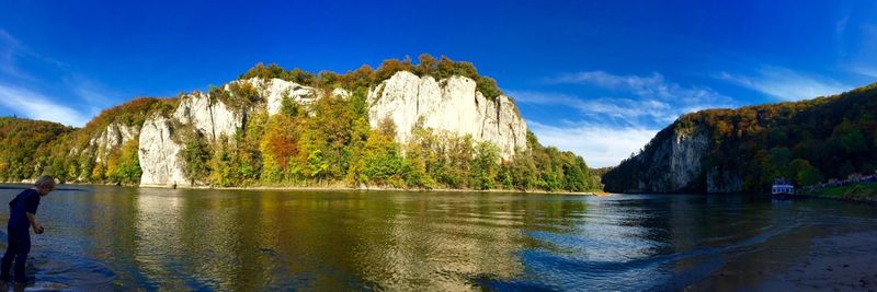 Scenic view of lake and mountains against blue sky