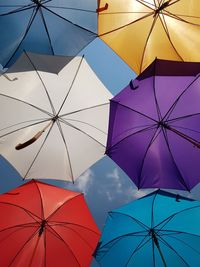 Low angle view of umbrellas hanging against sky