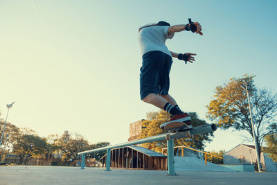 Low angle view of man jumping against sky