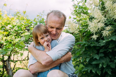 Portrait of young man sitting against plants