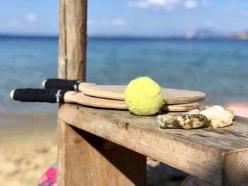 Close-up of balls on wooden table by sea