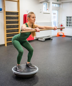 Full length of woman exercising in gym