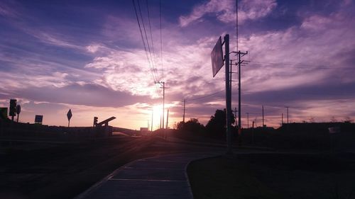 Electricity pylon against cloudy sky