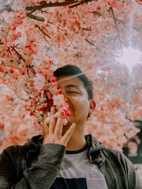Man smelling cherry blossom tree