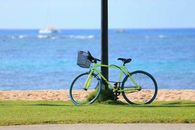 Bicycle by sea against sky