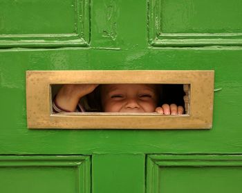 Close-up of boy looking through hole 