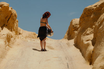 Rear view of woman standing on rock