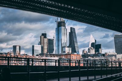 View of modern buildings against cloudy sky