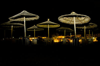 Illuminated beach against clear sky at night