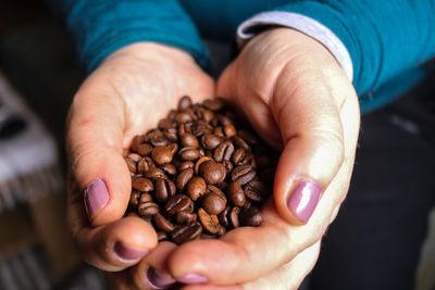 Midsection of man holding coffee beans