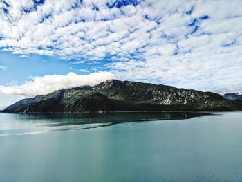 Scenic view of sea and mountains against sky