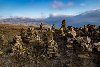 Stack of rocks on landscape against sky