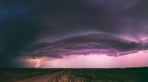 Scenic view of storm clouds over field