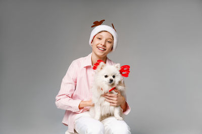 Best friends handsome boy with deer antlers and blond spitz love to spend