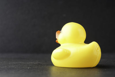 Close-up of yellow toy over black background