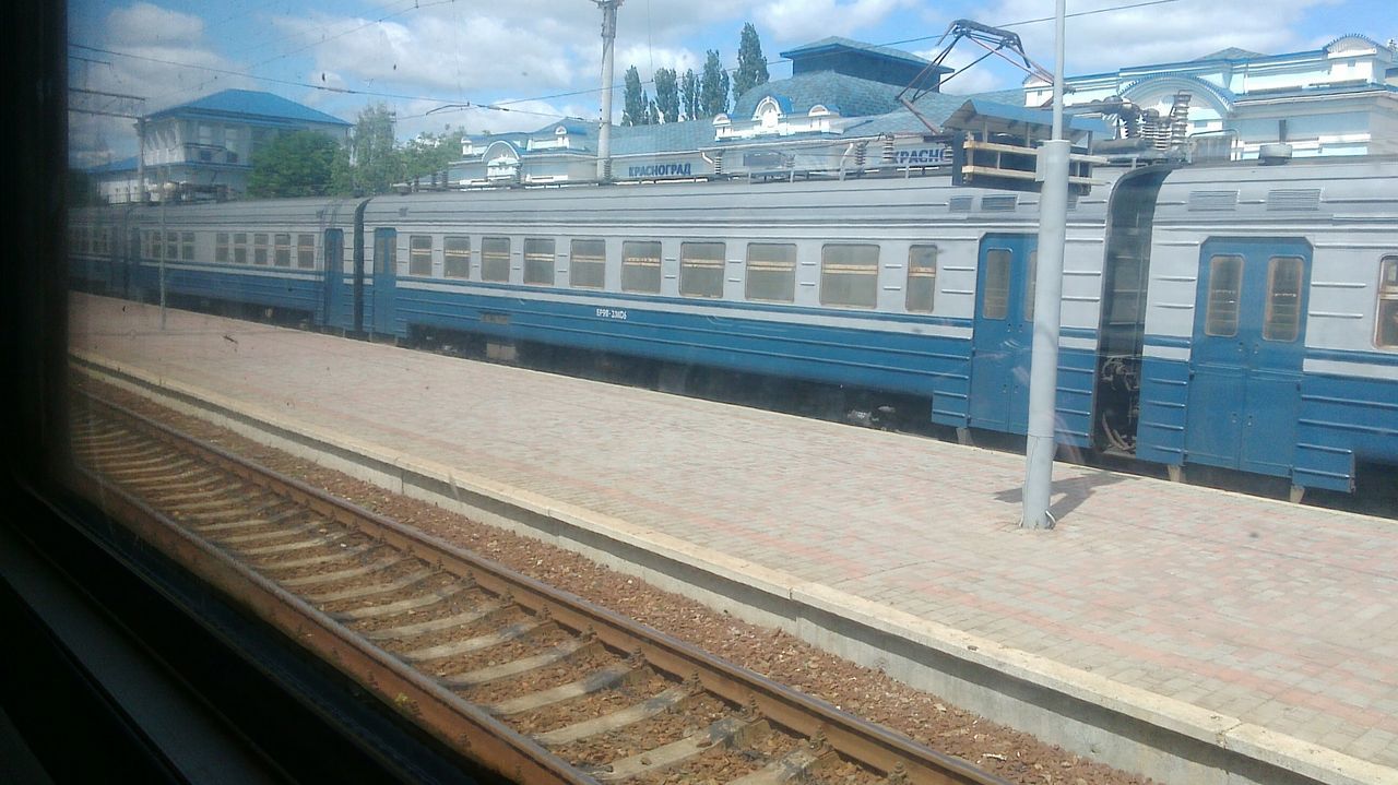 railroad track, transportation, public transportation, rail transportation, railroad station platform, railroad station, built structure, architecture, train - vehicle, building exterior, mode of transport, train, sky, city, passenger train, indoors, window, travel, public transport, glass - material