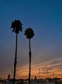 Silhouette palm trees against sky at sunset