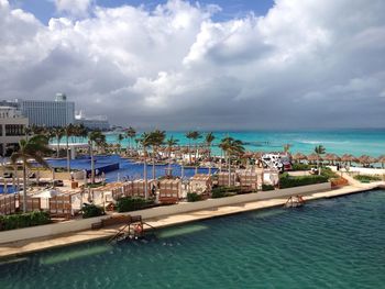 High angle view of resort by sea against cloudy sky