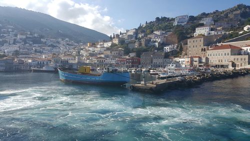 Aerial view of townscape by sea against sky