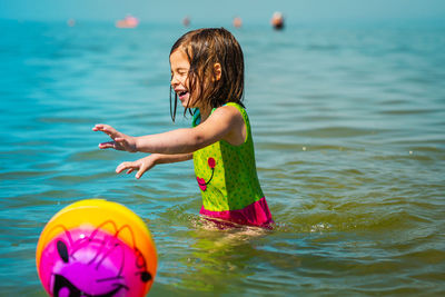 Girl playing with ball at beach