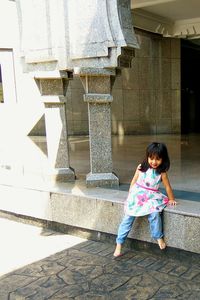 Portrait of happy girl standing on steps