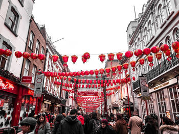 People on street against buildings in city