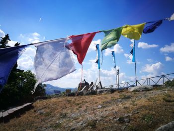 Low angle view of flags hanging against sky