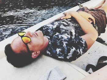 High angle view of man wearing sunglasses relaxing on boat