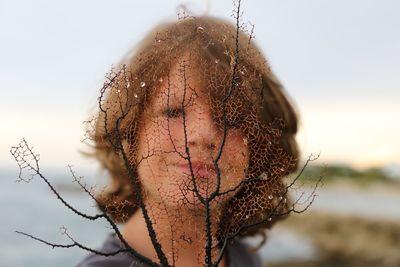 Woman seen through dried plant