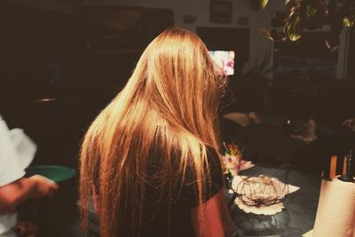 Rear view of woman sitting on sofa