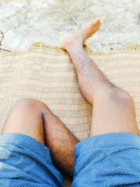 Low section of man relaxing on swimming pool