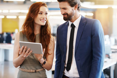 Business people talking while looking at digital tablet