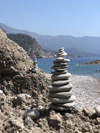 Stack of stones in sea against sky
