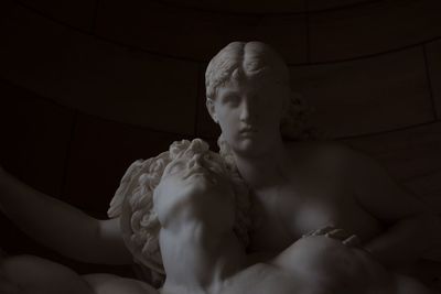 Statue of man relaxing on bed