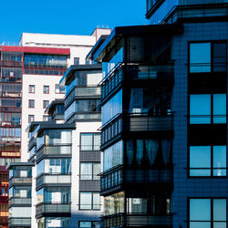 Low angle view of modern buildings against clear blue sky