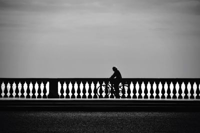 Rear view of silhouette woman standing against clear sky