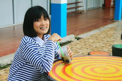 Portrait of smiling woman having drink at cafe