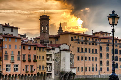 Buildings in city against cloudy sky