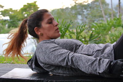 Portrait of woman looking away while sitting outdoors