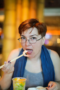 Portrait of mature woman eating seafood at restaurant