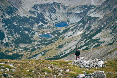 Rear view of person on rock against mountains