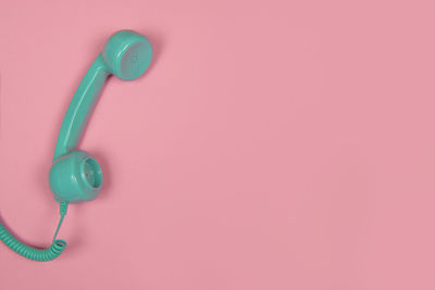 Close-up of telephone pole against pink wall