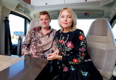Portrait of smiling couple sitting in motor home